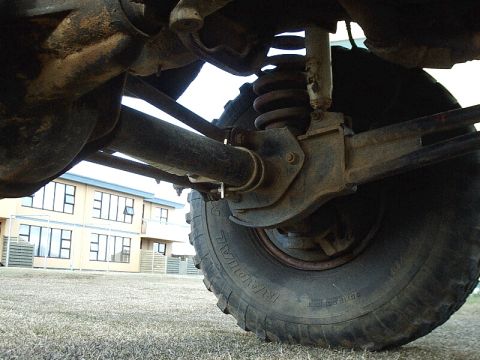 1996 Ford Bronco - Undercarriage view of a vehicle's suspension system, including a tire and shock absorber.