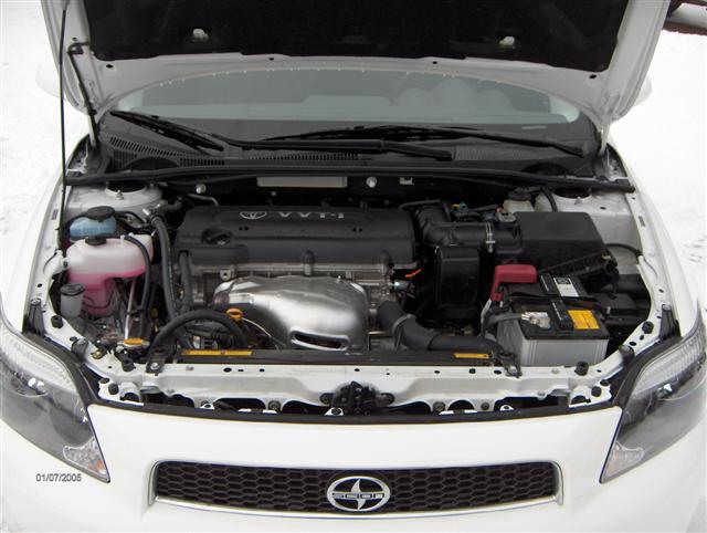 Scion engine bay with VVT-i four-cylinder, hood up, Scion badge on grille in snowy setting