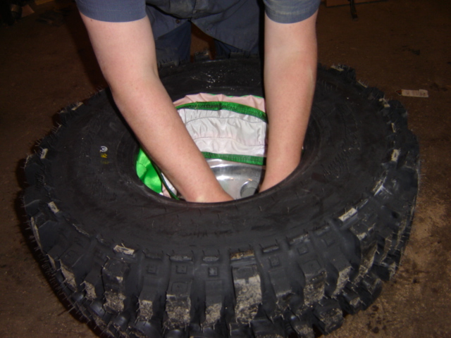 person installing a tire with hands