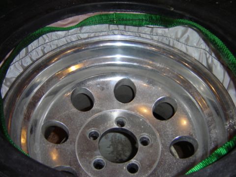 1992 Ford Bronco - Close-up of a wheel assembly, showing the tire, rim, and a green strap.