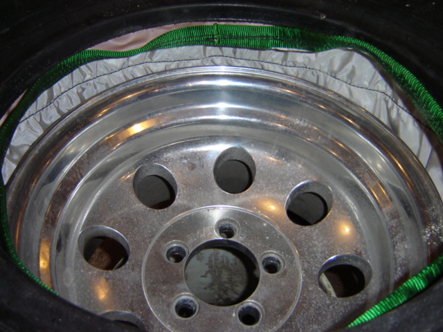 Aluminum alloy wheel with five lug holes, tire, and green strap
