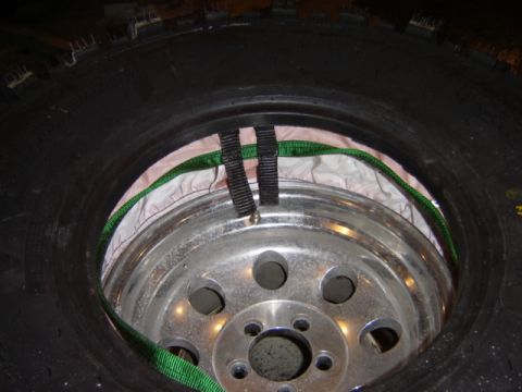 1992 Ford Bronco - A tire and wheel assembly is shown with straps securing it, possibly for transport or storage.
