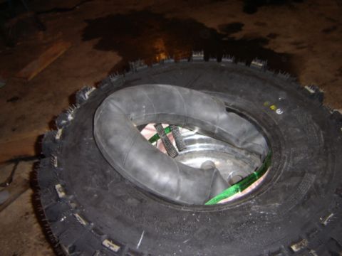 1992 Ford Bronco - Close-up of an off-road tire with an inner tube and securing straps.