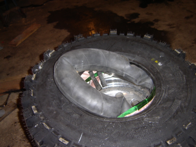 Off-road tire with inner tube and green straps inside