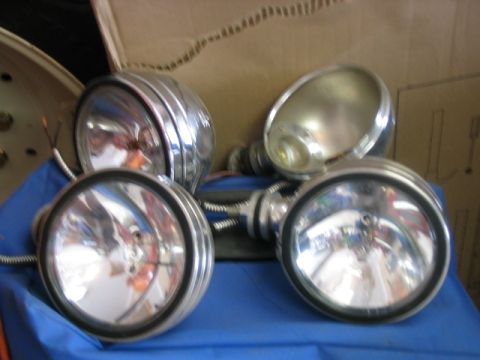 1986 Ford F-150 - Four vintage headlights are displayed on a blue cloth, with a cardboard box in the background.