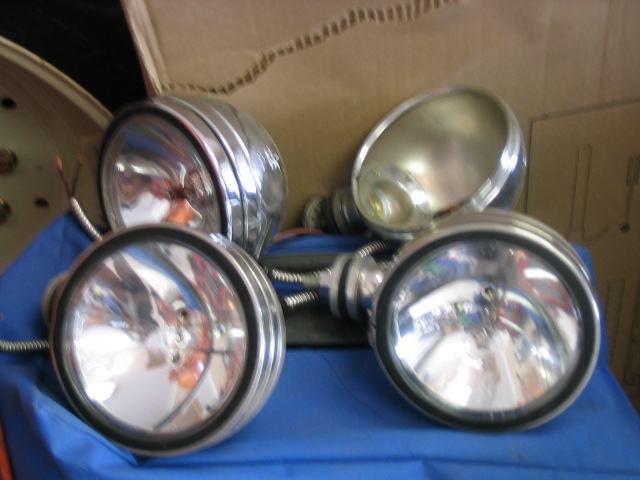 Four chrome-bezeled headlights on a blue cloth
