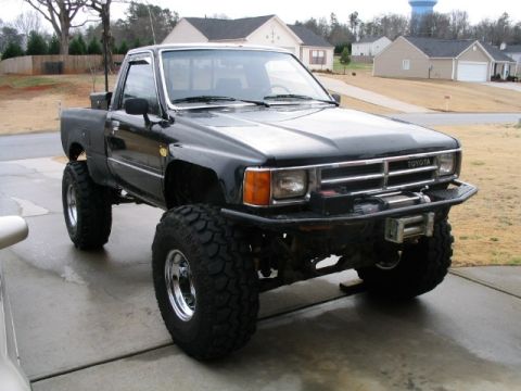 1986 Ford F-150 - This lifted Toyota pickup truck features a winch and aggressive off-road tires.