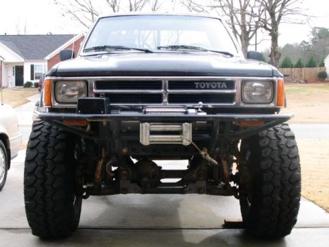 1986 Ford F-150 - Front view of a modified Toyota truck with a winch and off-road tires.