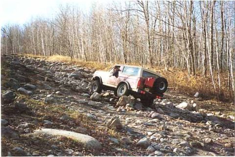 1989 Ford Bronco - This 1989 Ford Bronco navigates a challenging rocky incline, its off-road capability.