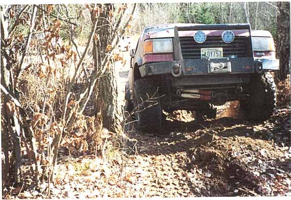 1989 Ford Bronco rear view, off-roading on dirt path with winch and custom bumper