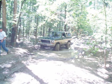 1978 Ford Bronco - This two-tone Ford Bronco is navigating a muddy trail through a forest.