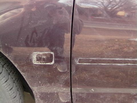1995 Ford Contour - Side view of a car door with a damaged trim piece and visible dirt.