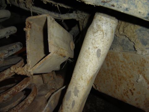 1992 Ford Bronco - This image shows heavily rusted suspension components and frame elements of a vehicle, with visible wiring and springs.