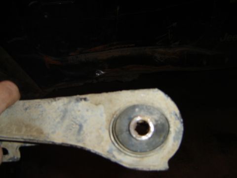 1992 Ford Bronco - A close-up view of a vehicle suspension component, likely a control arm bushing, showing wear and dirt.