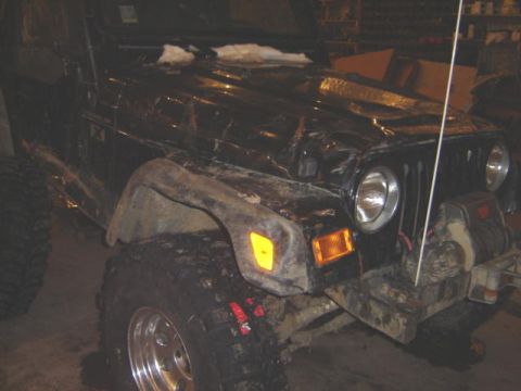1992 Ford Bronco - This black Jeep Wrangler features a winch and oversized tires, suggesting off-road modifications.