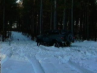 1991 Ford Bronco - 1991 Ford Bronco navigating a snow-covered road through a forest.