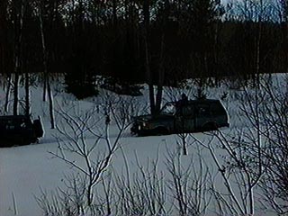1991 Ford Bronco - Two SUVs are visible in a snow-covered landscape with trees in the background.