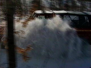 1991 Ford Bronco - Vehicle driving through a snow-covered area, partially obscured by spray.
