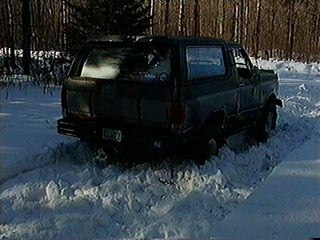 1991 Ford Bronco - 1991 Ford Bronco stuck in snow, rear view, winter scene.