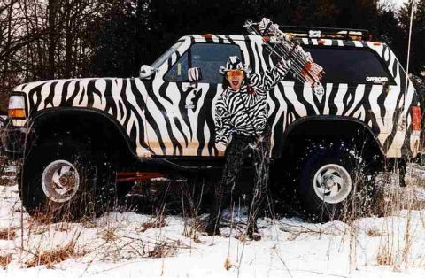 1985 Ford Bronco - A person in a zebra-patterned outfit poses with a similarly decorated SUV in a snowy outdoor setting.