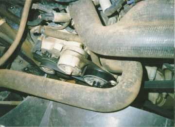 1991 Ford Bronco - Close-up of the alternator and belt system, likely from a vehicle's engine compartment.