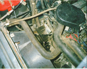 1991 Ford Bronco - Close-up view of engine components, including hoses and electrical wiring.