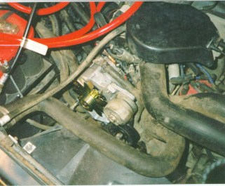 1991 Ford Bronco - Close-up view of the engine compartment, focusing on the alternator and surrounding components.