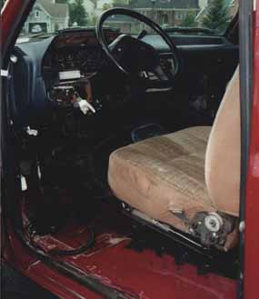 1991 Ford Bronco - The interior of a red vehicle is shown, with the dashboard and passenger seat visible.
