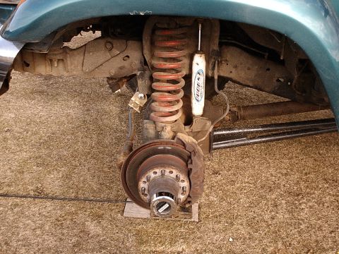 1996 Ford Bronco - The front suspension and wheel hub assembly of a vehicle are shown, with focus on the coil spring and shock absorber.