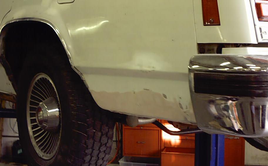 White 1985 Ford Crown Victoria LTD rear quarter panel with rust and chrome bumper