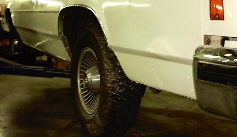1985 Ford LTD Crown Victoria - Close-up of the rear wheel well and chrome bumper on a 1985 Ford Crown Victoria LTD.