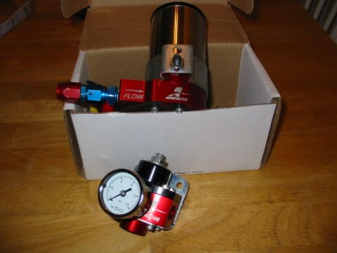 1985 Ford Crown Victoria LTD - A red fuel pressure regulator with a VDO gauge and 'FLOW' label is shown, partially in a box.