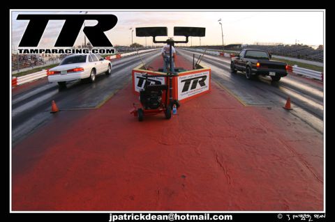 1997 Ford Crown Victoria - A white 1997 Ford Crown Victoria competes in a drag race, with another vehicle visible in the adjacent lane.
