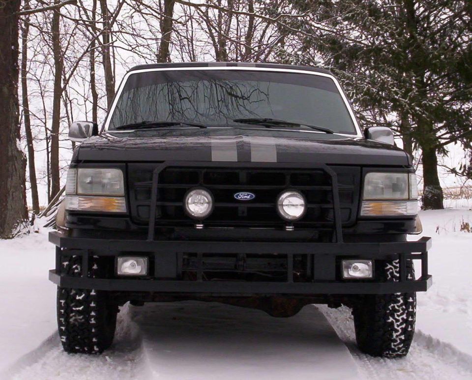 1993 Ford Bronco front view in snow, with bull bar and dual racing stripes
