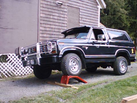 1981 Ford Bronco - This black 1981 Ford Bronco is shown with a chrome grille guard and its front wheel elevated on a ramp.