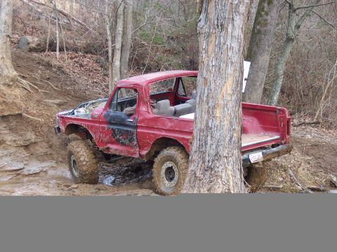 1978 Ford Bronco - A red 1978 Ford Bronco is stuck in the mud on an off-road trail.