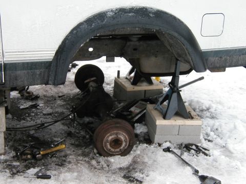1994 Ford Bronco - Vehicle rear axle assembly removed and supported by jack stands in a snowy environment.