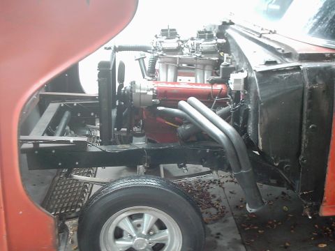 1978 Ford Bronco - Close-up of a modified V8 engine with dual carburetors and custom exhaust pipes.