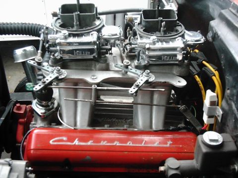 1978 Ford Bronco - Close-up of a Chevrolet V8 engine dual Holley carburetors and red valve covers.