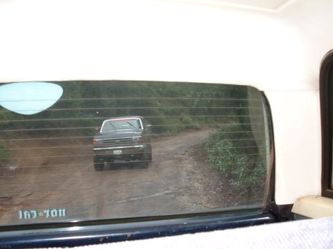 1990 Ford Bronco - A Ford truck is seen from behind on a dusty, rural road.