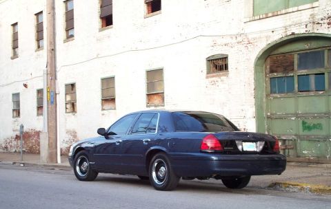 1998 Ford Crown Victoria - Dark blue 1998 Ford Crown Victoria parked on a street in front of an old brick building.