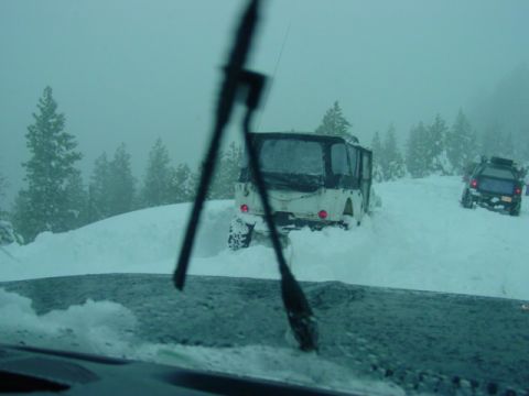 1986 Ford Bronco - Two SUVs navigate a snowy landscape, with one appearing stuck in the deep snow.