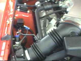2000 Ford Mustang - Close-up view of a vehicle's engine bay, showing the air intake system and engine components.