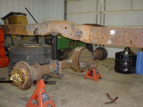 1978 Ford F-350 - Truck frame and axles on jack stands, with a John Deere mower in the background.
