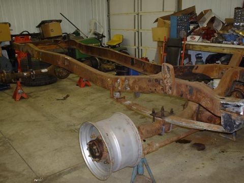 1978 Ford F-350 - A heavily rusted truck frame is visible in a workshop setting, undergoing restoration.
