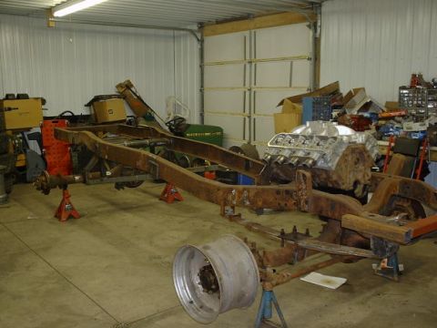 1978 Ford F-350 - Truck frame and engine block in a garage setting, undergoing restoration or assembly.