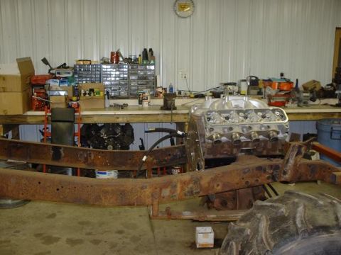 1978 Ford F-350 - A workshop scene shows a disassembled vehicle frame and engine, with tools and parts on shelves in the background.