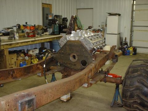 1978 Ford F-350 - Engine and chassis frame assembly in a workshop setting, with tools and equipment in the background.