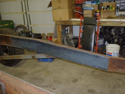 1978 Ford F-350 - A section of a truck frame has a new metal plate welded onto it, with tires and a green tractor in the background.