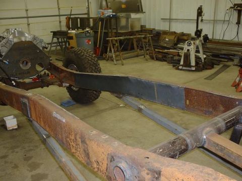 1978 Ford F-350 - Workshop scene showing a vehicle frame, engine, and tire during a build or repair.